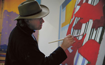 The artist David Bent painting in his studio