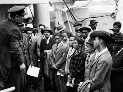 Airmen and veterans on board HMT Empire Windrush being welcomed by RAF officials from the Colonial Office, Tilbury, 21-22 June 1948 (Courtesy of Press Association Archive) Flight Lieutenant Johnny Smythe from Sierra Leone is standing second from left and Jamaican Sam King MBE is back row, far right. Airmen and veterans on board HMT Empire Windrush being welcomed by RAF officials from the Colonial Office, Tilbury, 21-22 June 1948 (Courtesy of Press Association Archive) Flight Lieutenant Johnny Smythe from Sierra Leone is standing second from left and Jamaican Sam King MBE is back row, far right.