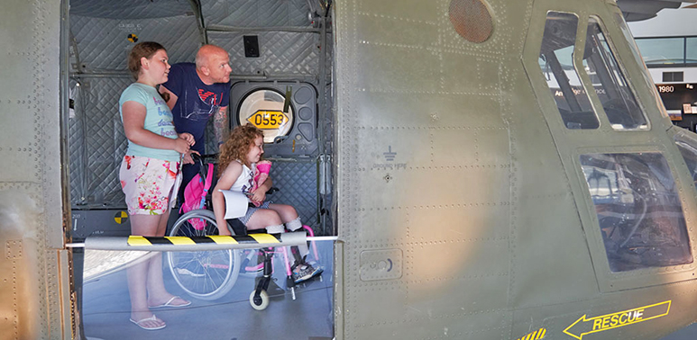 Visitors inside the nose section of the Chinook helicopter in 'RAF in the Age of Uncertainty: 1980 - Today' exhibition at the RAF Museum London