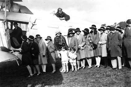 Sir Alan Cobham in the cockpit of his de Havilland D.H.61 biplane with a line of children waiting for their free flight Sir Alan Cobham in the cockpit of his de Havilland D.H.61 biplane with a line of children waiting for their free flight